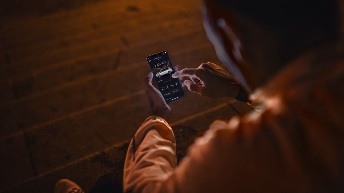 Člověk držící telefon s aplikací MyCUPRA