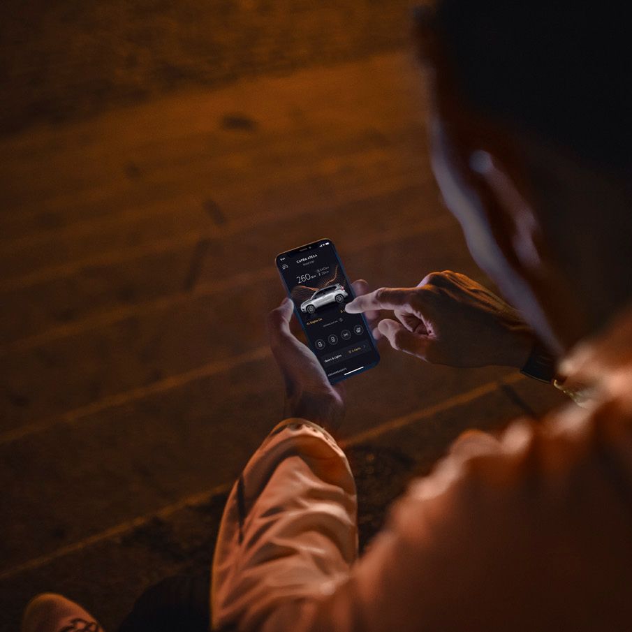 Člověk držící telefon s aplikací MyCUPRA