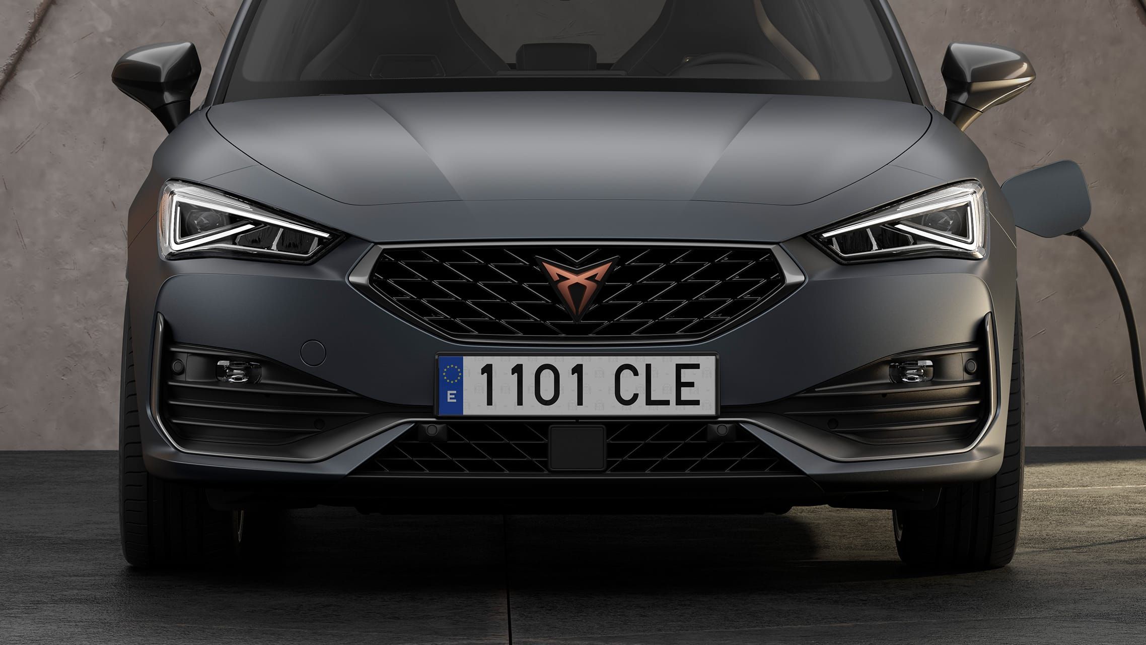 Nový kompaktní sportovní vůz CUPRA Leon ehybrid, záběr zblízka na masku chladiče, podběhy kol a zpětná zrcátka v tmavém hliníku