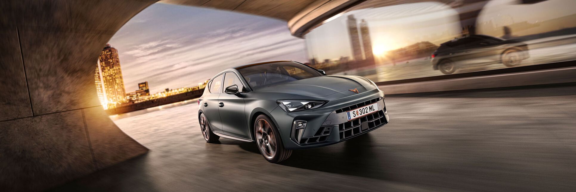Schräge Vorderansicht eines grauen CUPRA Leon in voller Fahrt.