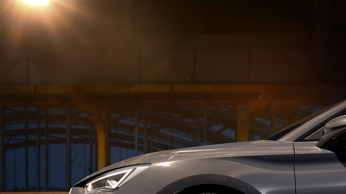 Nový kompaktní sportovní vůz CUPRA Leon 5D ehybrid v barvě magnetic šedá matná, boční pohled zpředu při nabíjení
