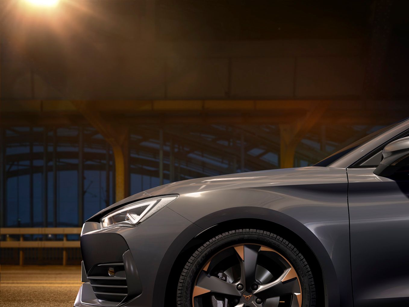 Nový kompaktní sportovní vůz CUPRA Leon 5D ehybrid v barvě magnetic šedá matná, boční pohled zpředu při nabíjení