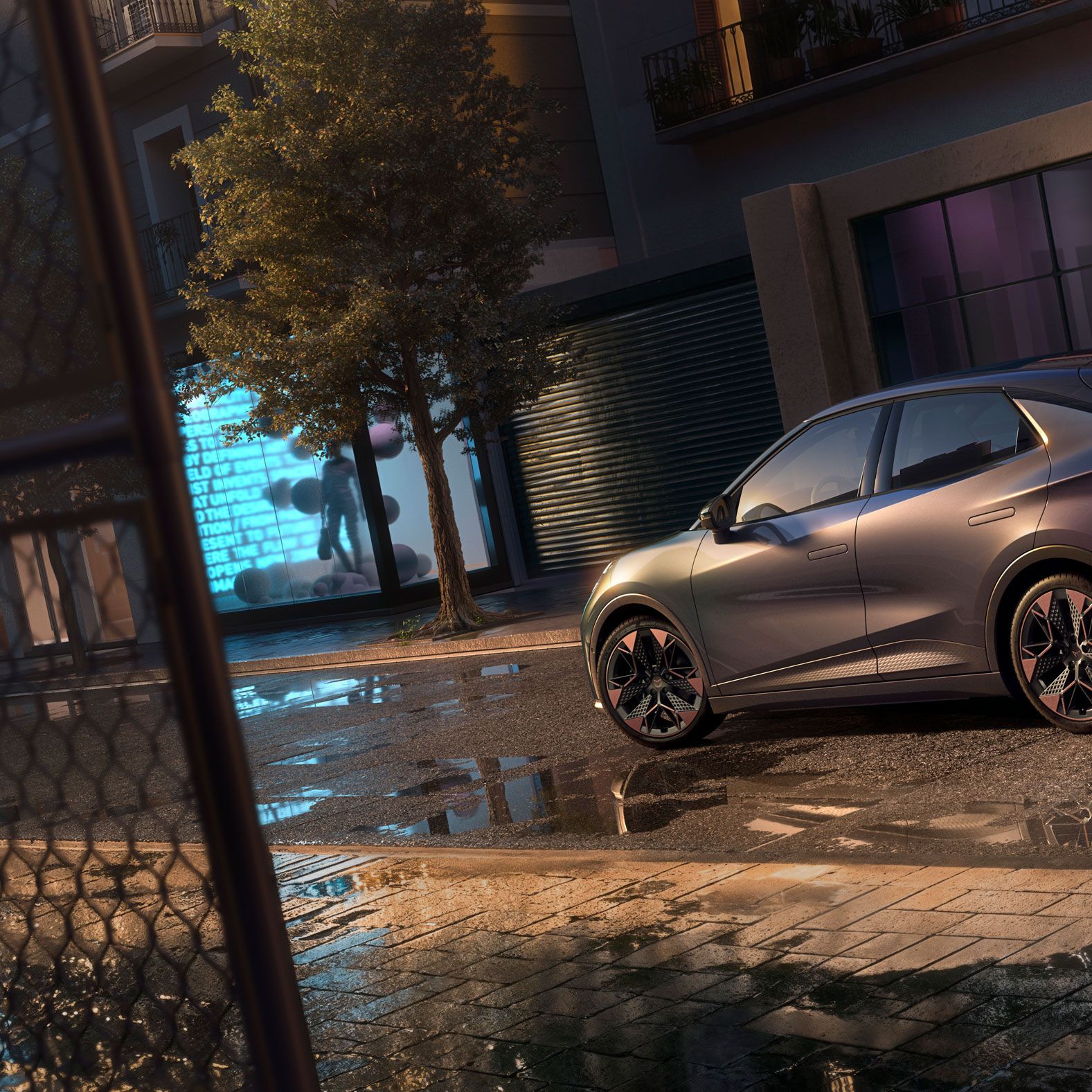 Nahaufnahme der Heckansicht des CUPRA Raval VZ in Plasma mit 19-Zoll-Felgen, geparkt auf einer städtischen Straße bei Nacht.