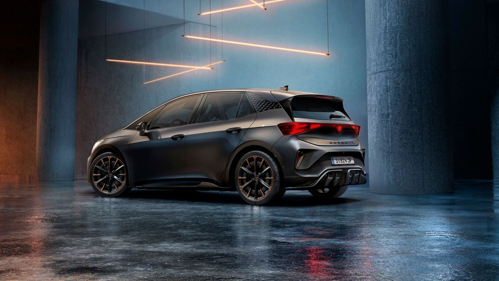 Ein CUPRA Born steht in einem stilvoll beleuchteten, industriellen Raum mit Betonwänden und -säulen. Von der Decke hängen mehrere lineare Lichtquellen, die ein elegantes Ambiente schaffen. Das Fahrzeug ist rückseitig zu sehen und reflektiert das Licht auf dem glänzenden Boden.