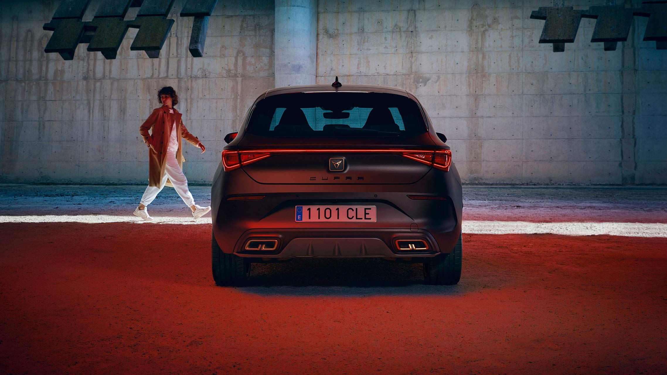 Nový kompaktní sportovní vůz CUPRA Leon 5D ehybrid v barvě magnetic šedá matná, boční pohled zezadu při nabíjení