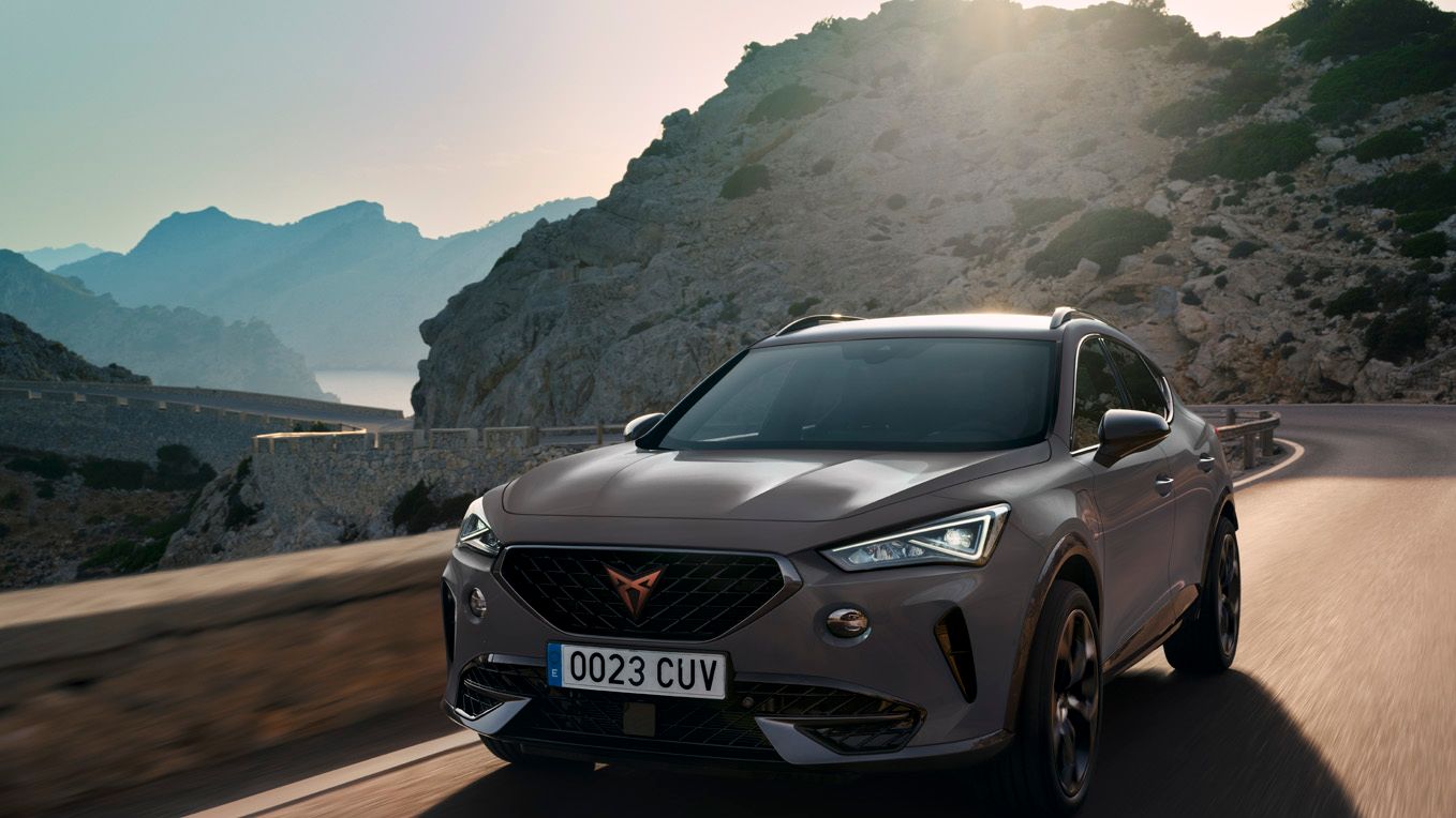 Nový kompaktní sportovní vůz CUPRA Leon 5D ehybrid v barvě magnetic šedá matná, boční pohled při nabíjení 