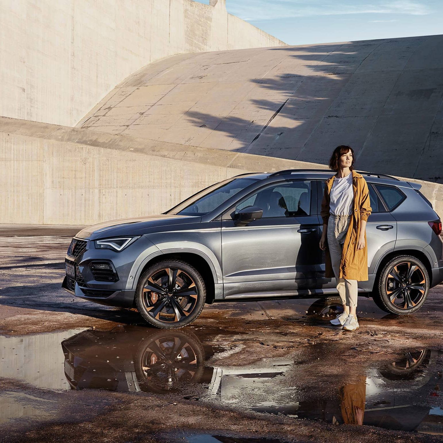 CUPRA Ateca 2020 v barvě rodium šedá boční pohled a žena stojící před vozem