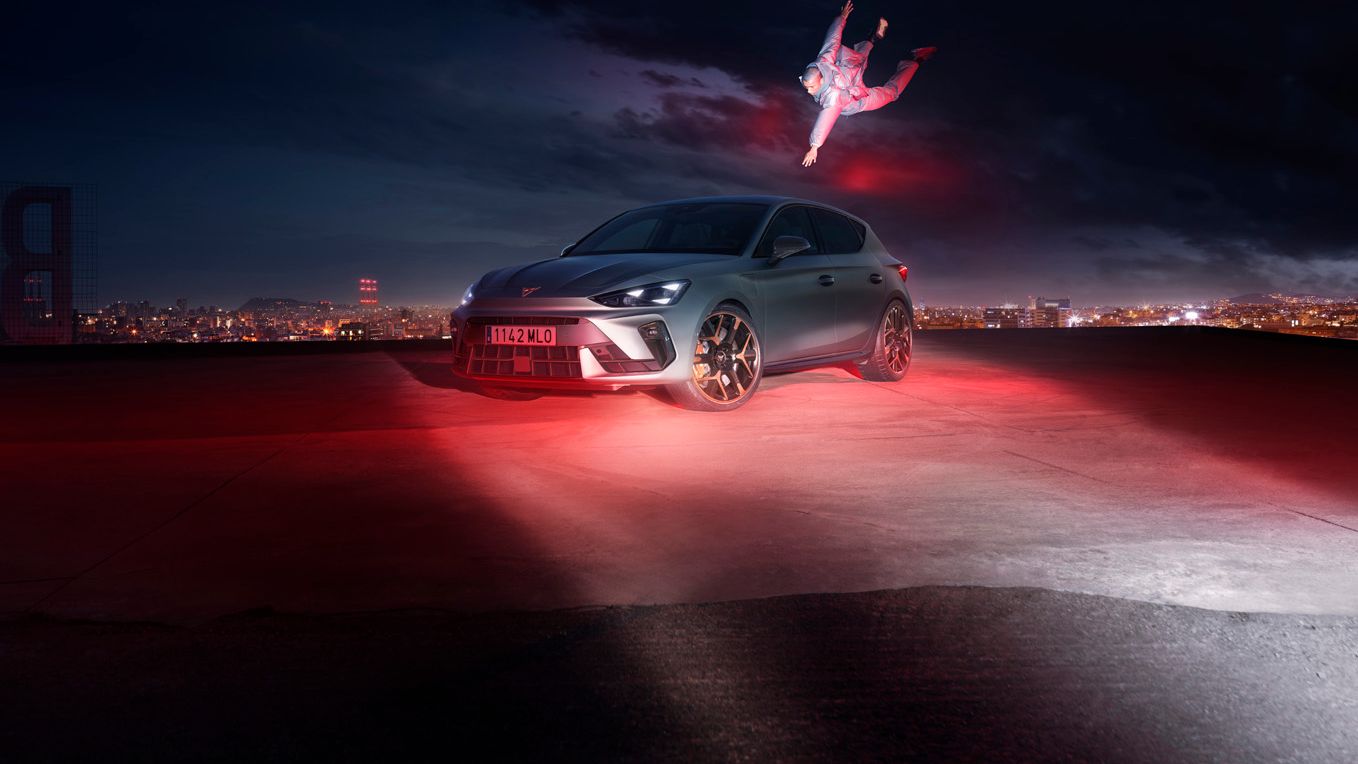Ein CUPRA Leon in voller Fahrt. Im Hintergrund die Skyline einer Stadt.