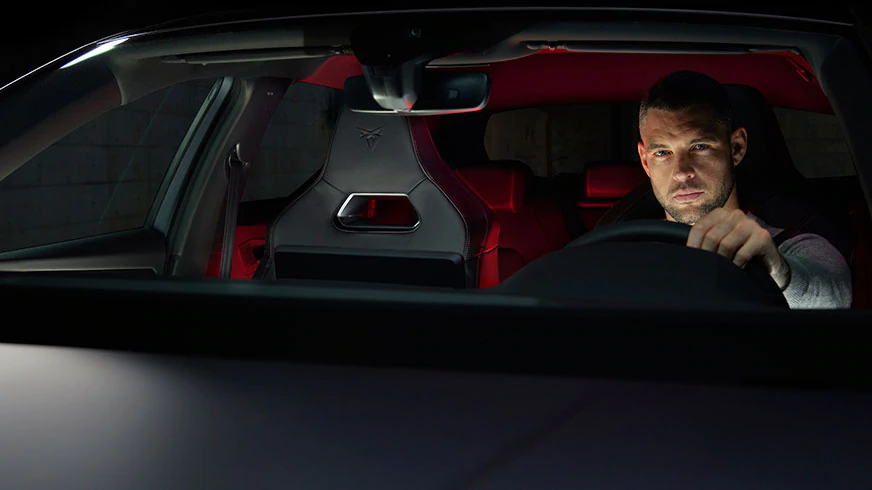 Blick durch die Frontscheibe eines CUPRA Leon e-Hybrid, ein Mann sitzt am Steuer