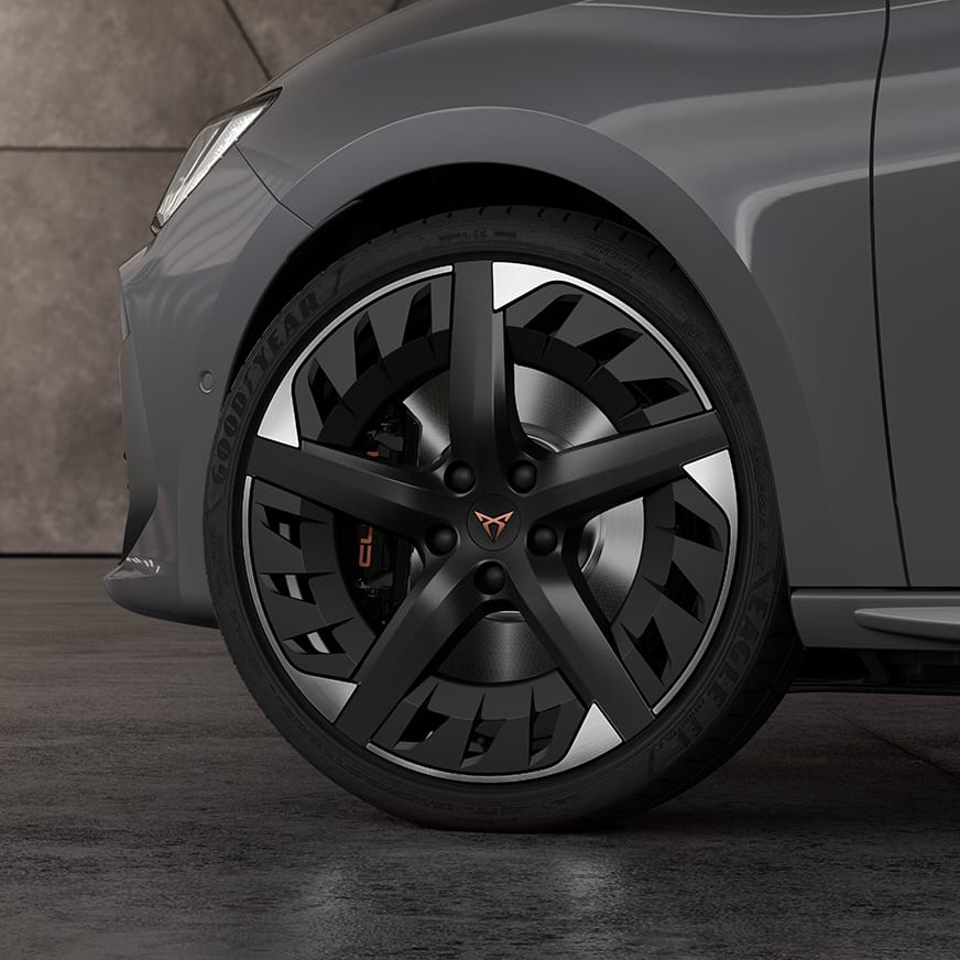 Nový kompaktní sportovní vůz CUPRA Leon 5D ehybrid s broušenými 19“ koly z lehkých slitin v barvách černá a stříbrná. Pohled zblízka.